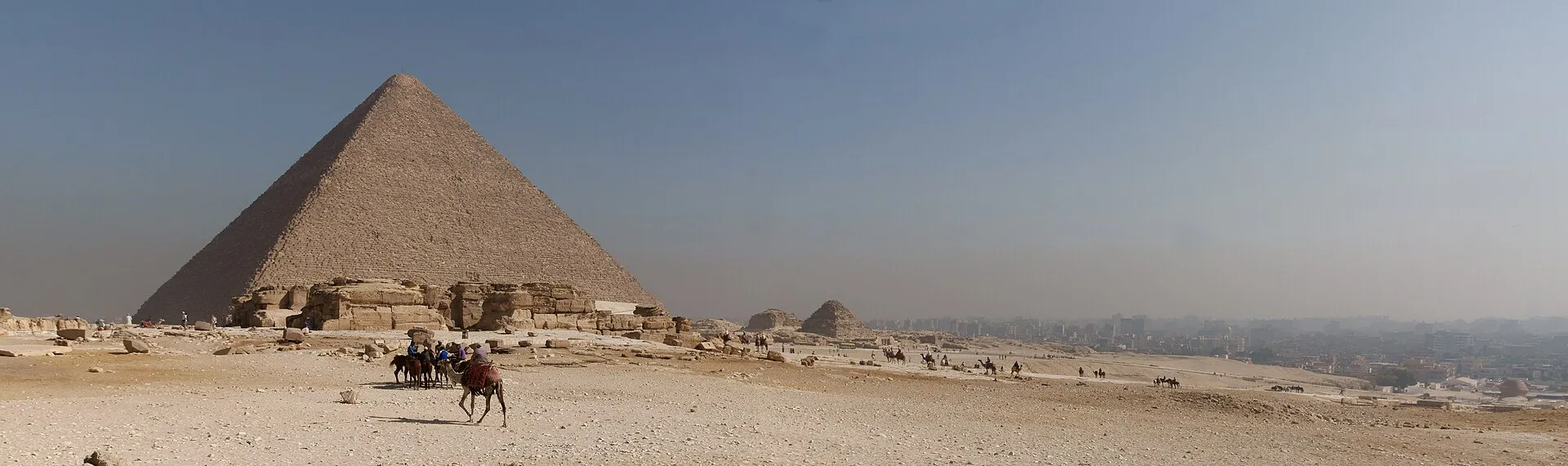 The Great Pyramid of Giza with camels in the sandy foreground